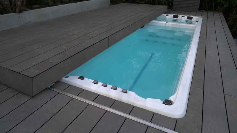 Der Pool verfügt über eine verfahrbare Poolabdeckung.Die Poolabdeckung ist zur Hälfte geöffnet und ist aus Holz.